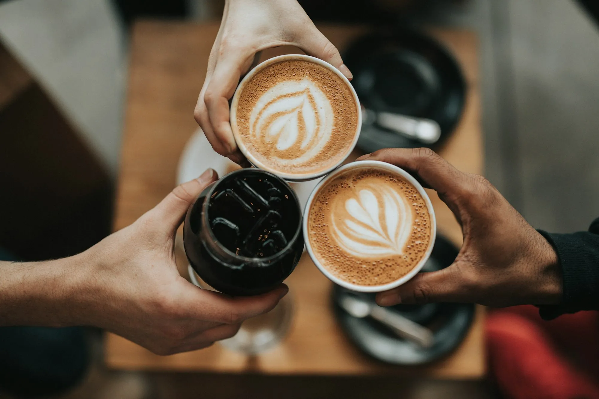 Taza de café recién servida sobre una mesa de madera